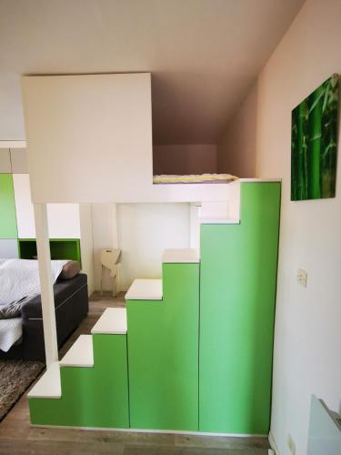 une chambre avec un lit superposé vert et blanc dans l'établissement Le petit Bois en bord de mer - accès animations, commerce et plage, à Argelès-sur-Mer