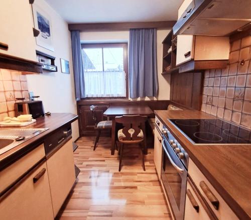 a small kitchen with a table and a dining room at Appartements Bergheim in Pettneu am Arlberg