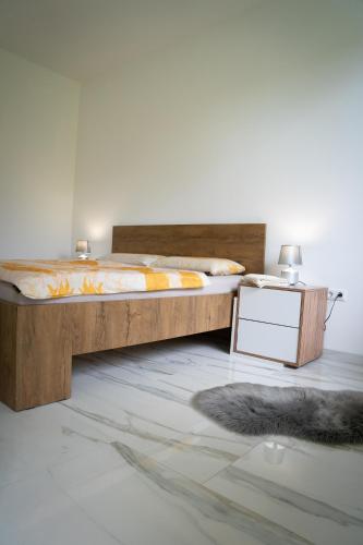 a bedroom with a large wooden bed and a night stand at Apartment Una Laguna in Bihać