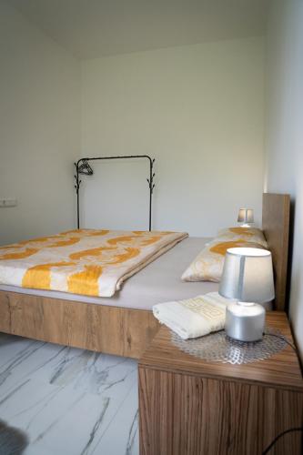 a bedroom with a bed and a table with a lamp at Apartment Una Laguna in Bihać