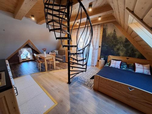 Zimmer mit einem Bett und einer Wendeltreppe in der Unterkunft Apartamenty U Paliderki in Poronin