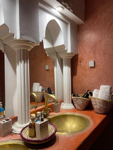 La salle de bains est pourvue d'un lavabo et de deux miroirs. dans l'établissement Riad La Calèche & SPA, à Marrakech