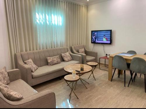 sala de estar con sofá y mesa en Alwaha-Appartement en Riad