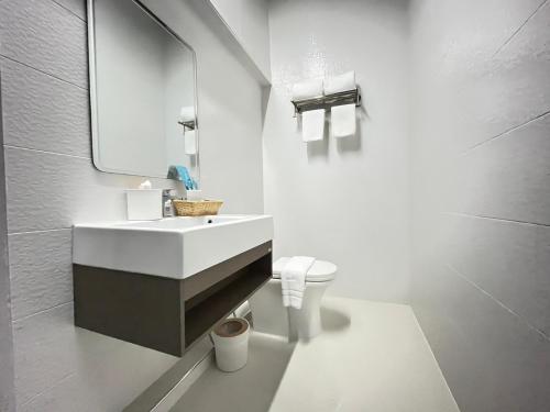 a white bathroom with a sink and a toilet at DMhotel&cafe in Nan