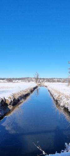 a river in a field with snow on the ground at Boutique Hotel Angerer in Murnau am Staffelsee