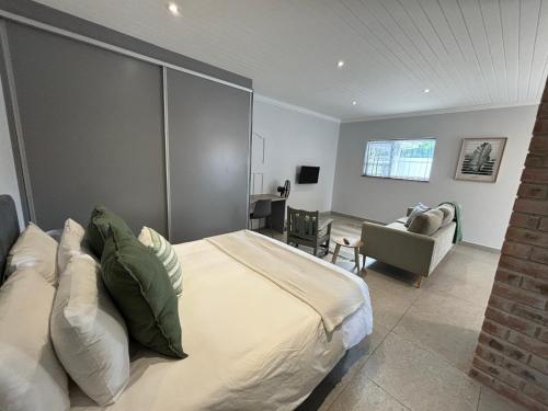 a bedroom with a bed and a couch and a chair at Prospect Road Cottage in Walmer