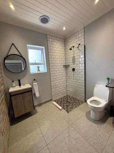 a bathroom with a shower and a toilet and a sink at Prospect Road Cottage in Walmer