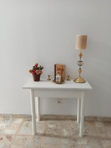 a white table with a lamp and flowers on it at Conde Lucanor in Belmonte