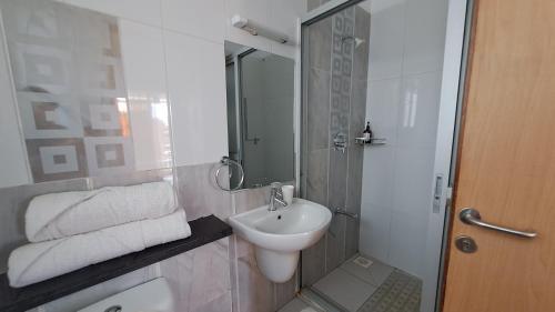 a white bathroom with a sink and a shower at Ary Homestay Nyali- Town Home Behind Citymall in Mombasa