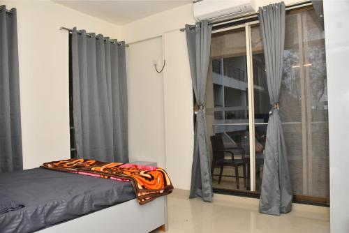 a bedroom with a bed and a window at HAZYHILLS Staycation in Igatpuri