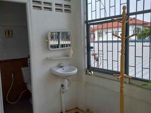 a bathroom with a sink and a window at Happy Hostel in Bangkok