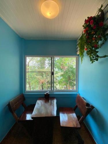 a room with two wooden tables and a window at Saiyok River House in Sai Yok