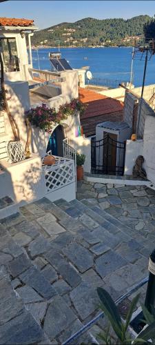 a house with a stone patio with a view of the water at Final step in Skiathos Town