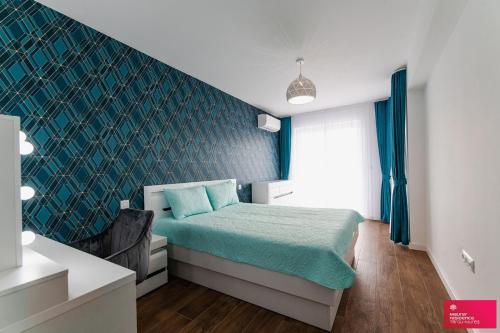 a bedroom with a bed with a green accent wall at The Cozy One in Târgu-Mureş