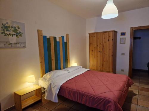 ロッカラーゾにあるResidenze Macerelliのベッドルーム1室(ベッド1台付)、木製キャビネットが備わります。