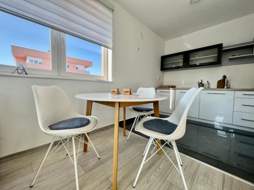 eine Küche mit einem Tisch und Stühlen im Zimmer in der Unterkunft Apartman Sunny, Istocno Sarajevo - Lukavica in Sarajevo
