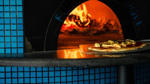 a pizza is being cooked in an oven at Joy Island Maldives All Inclusive Resort in Male City