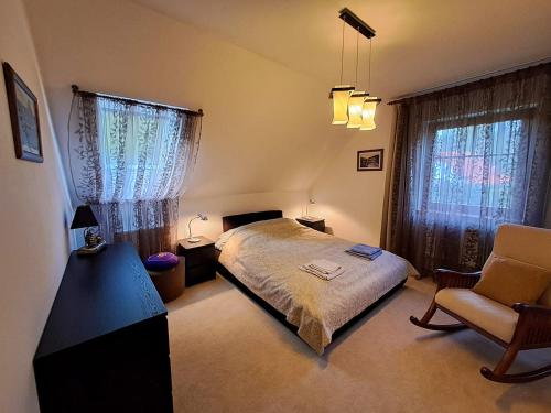 una camera con letto, sedia e finestre di Villa Gejzir 37 a Karlovy Vary