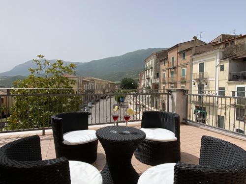a table with chairs and wine glasses on a balcony at Terrazza su Tocco in Tocco da Casauria