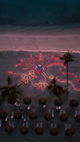 a reflection of a heart on the beach at night at Joy Island Maldives All Inclusive Resort in Male City