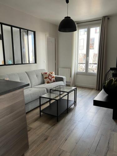 un salon avec un canapé et une table dans l'établissement Bright, quiet and cozy apartment Top Location, à Saint-Ouen