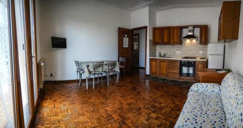 a kitchen with a wooden floor and a table and chairs at Agriturismo La Rocca in San Bartolomeo al Mare