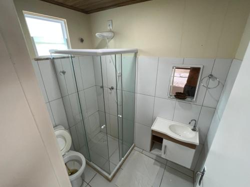Apartamento em Itaparica في Bôca do Rio: حمام مع دش ومرحاض ومغسلة
