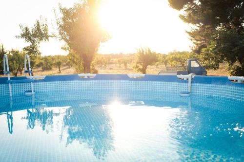 una piscina con il sole che si riflette nell'acqua di Casa in campagna ⋅ ForiMìa a San Vito dei Normanni