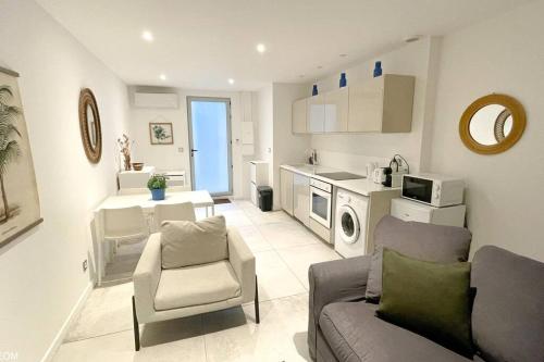 un salon avec un canapé et des chaises et une cuisine dans l'établissement Apt T2 neuf, terrasse, centre ville, 8min Comédie, à Montpellier