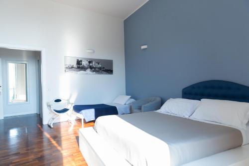 1 dormitorio con cama blanca y pared azul en B&B Palazzo Mirelli, en Nápoles