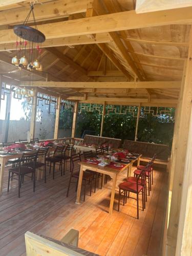 comedor con mesas y sillas en una terraza de madera en Dungan House en Karakol