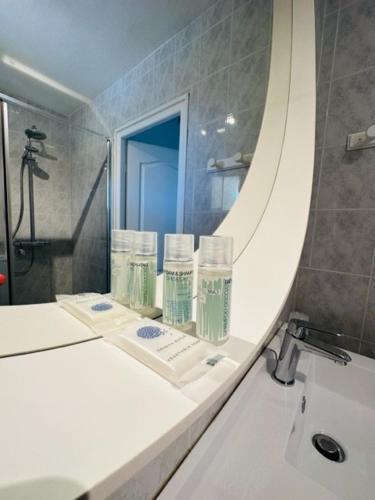 une salle de bain avec un lavabo et un miroir dans l'établissement L'arbre qui chante, à Saint-Étienne-de-Sermantin