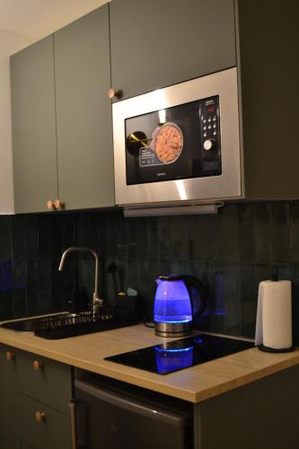 a kitchen with a microwave above a stove top at Studio 88 in Courbevoie
