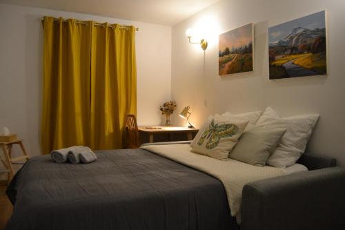 a bedroom with a bed and a yellow curtain at Studio 88 in Courbevoie