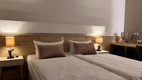 a bedroom with a large white bed with two lamps at Harz hotel Iris in Sieber
