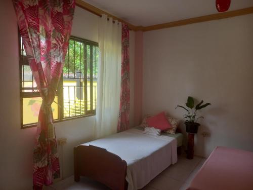 a small bedroom with a bed and a window at Café Darcey BnB in Tagbilaran City