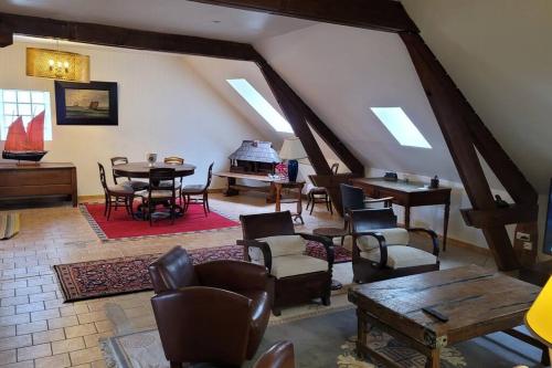 a living room with a table and chairs and a piano at F3 tout confort spacieux in Mauves-sur-Huisne