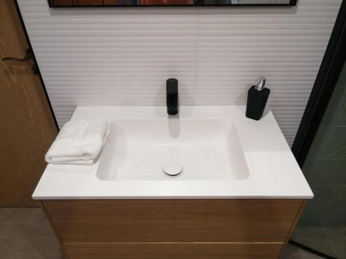 lavabo blanco en el baño con objeto negro en Liiva Guest Accommodation, en Tartu