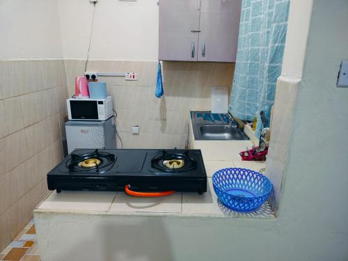 a small kitchen with a stove and a sink at Erica Homestay in Nanyuki