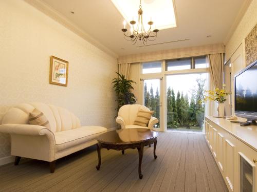 a living room with two chairs and a tv at Wellness Forest Nasu in Nasu