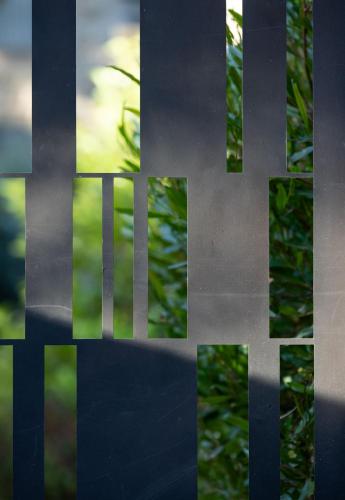 a close up of a metal fence with trees in the background at THE Y HOUSE in Jerusalem