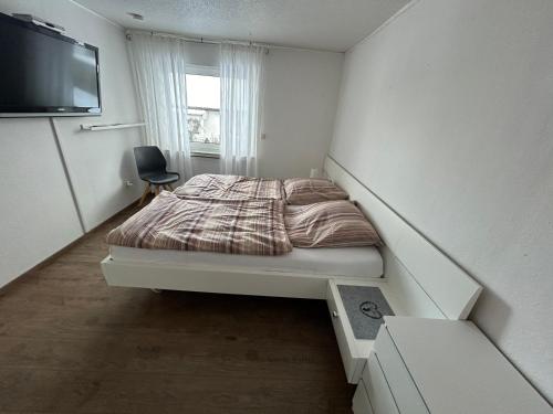 1 dormitorio pequeño con 1 cama y TV en Wohnung direkt am Wald, en Warstein