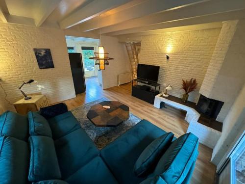 sala de estar con sofá azul y mesa en Bosrijke vakantiewoning en Lochem