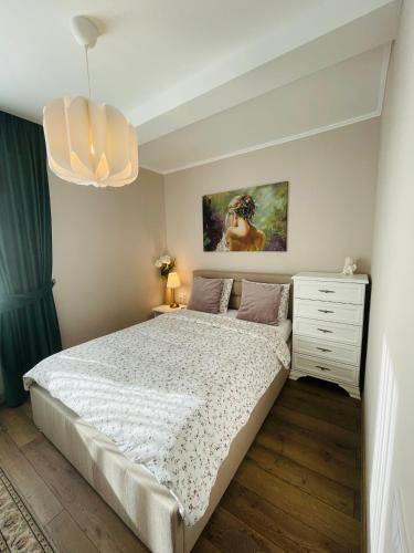 a bedroom with a large bed and a chandelier at Apartament CETATE ALBA CAROLINA in Alba Iulia