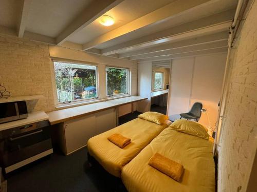 a hotel room with two beds and a window at Bosrijke vakantiewoning in Lochem