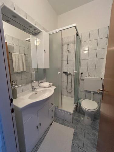 y baño con lavabo, aseo y ducha. en Pension Rušev, en Preko