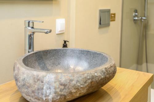 La salle de bains est pourvue d'un lavabo en pierre sur un comptoir. dans l'établissement Skiathos Symbol Villas, à Achladies