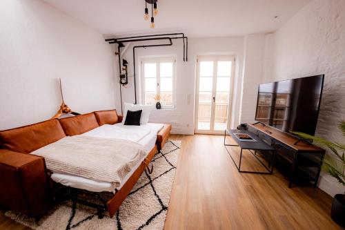a living room with a couch and a desk at Highlight am Stadtplatz Mühldorf - C4S COME4STAY - 2 Zimmer Wohnung I bis zu 5 Gäste in Mühldorf