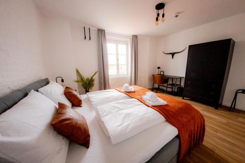 a bedroom with a large bed with white sheets and pillows at Highlight am Stadtplatz Mühldorf - C4S COME4STAY - 2 Zimmer Wohnung I bis zu 5 Gäste in Mühldorf