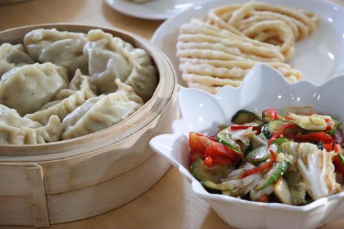 a table with two containers of food with dumplings at Dungan House in Karakol
